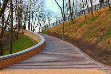 Wide angle landscape view of wide curved smooth descent by staircase. Famous city park - Saint Vladimir Hill (Vladimirskaya Gorka) after renovation. Beautiful spring morning. Kyiv, Ukraine