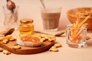 Sweet breakfast with cappuccino in a glass. Beige and orange monochrome color scheme, closeup view