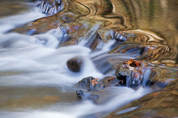 Landscape of a cascade on the Little River captured with motion blur and illuminated by reflected color from sunlit foliage, Great Smoky Mountains National Park, Tennessee, USA