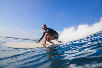 Female surfer on a wave - obrazy, fototapety, plakaty