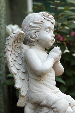 The white cupid sculpture decorated in the garden.