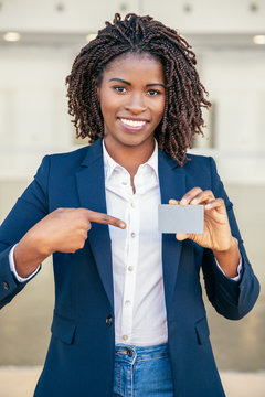 Happy confident businesswoman showing id card. Young African American business woman pointing at blank card, smiling. Presentation concept