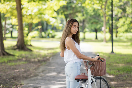 Beauty Asian woman with bike in park