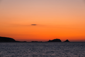 Naklejka na ściany i meble Sunset over red rock of Ile Rousse in Corsica