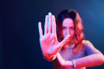 Portrait of young girl with curly hair in red and blue neon in studio