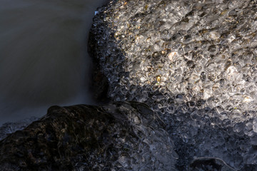 Clear ice in the brook in winter. Small frozen balls.