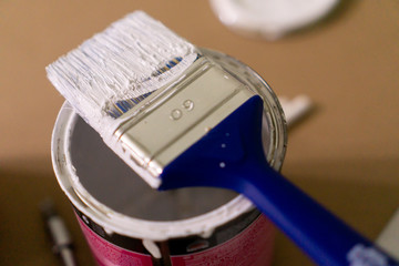 Dirty paintbrush sitting over a opened can with paint. Close up shot with rich details. © Sebastian88