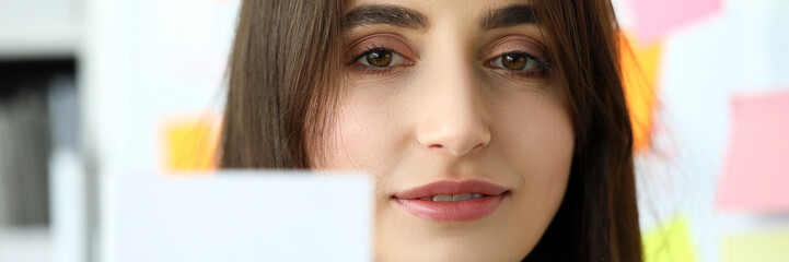 Naklejka premium Female arm in suit give blank calling card to visitor portrait. White collar colleagues company name exchange job interview sale clerk id executive or ceo finance support formal identity concept