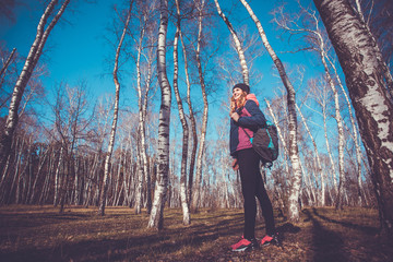 young woman walks in a spring birch forest.