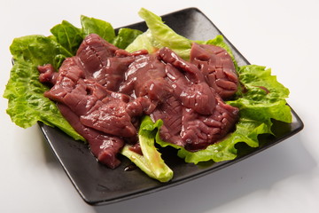 The pig's waist is put in the plate after playing the flower knife, isolated in the white background