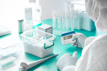 SARS-COV-2 nucleic acids diagnostics kit. Epidemiologist in protective suit, mask and glasses...