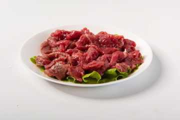 Australian beef slices are placed on plates, isolated in a white background