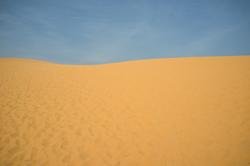 Ripple golden desert sand and blue sky as background. Sand and sky. Texture. Pattern, Decoration, Wallpaper.