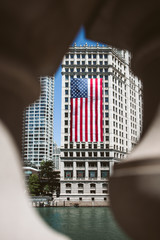 large american flag of united states of america hanging on the side of a building in the urban city to celebrate Independence Day on the fourth of July 
