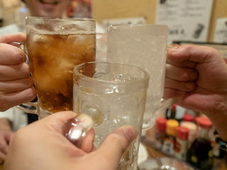 居酒屋でウーロンハイとレモン酎ハイのグラスで友達と乾杯をする © Yuzuru Gima
