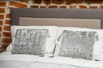 Pillows on the bed. Brick wall. Loft interior. Close-up.