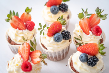 Fresh, delicious cupcakes with yogurt cream and fresh berries. Close up