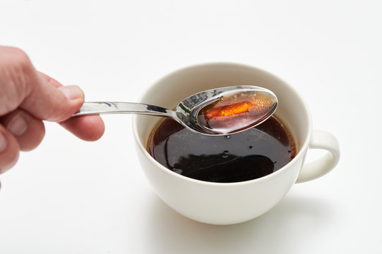 White cup of black bullet proof coffee with healthy oil on white table