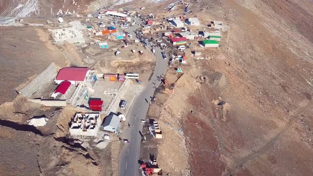 Aerial view of landing drone shot of Babusar pass in pakistan during autumn season when mountains are brown and peaks are snow covered