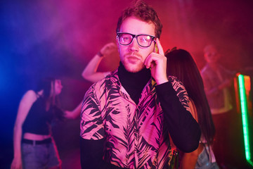 Young people is having fun in night club with colorful laser lights