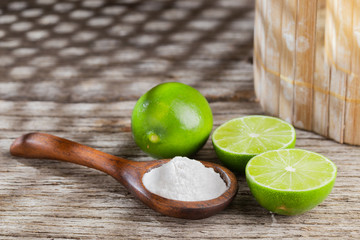 Baking soda and lemon on wooden background space for text