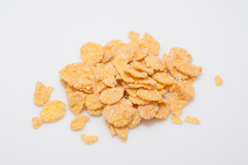 Pieces of golden corn flakes on white