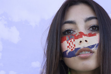 Flag of Croatia painted on a face of a smiling croatian young woman. Copyspace.