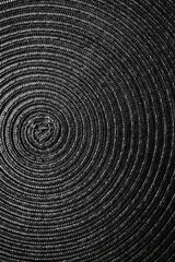 Fototapeta na wymiar Geometric black background, circles on fabric, interweaving of threads. Minimalism. Vertical photo.