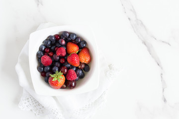 cuenco con frutos rojos vista desde arriba superficie blanca mármol mesa cocina