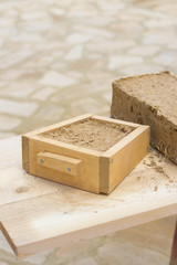 molde de madera para hacer ladrillo de barro y paja en bioconstrucción