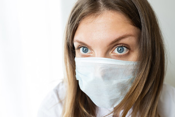 Close up of a female nurse putting on a mask to protect from airborne respiratory diseases such as the flu, coronavirus, ebola, TB, etc copyspace