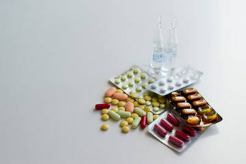 Multi-colored pills and capsules on a white background. Pills in a plastic blister. Healthcare and medicine concept.