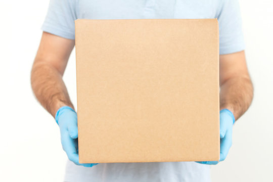 Delivery man holding cardboard boxes in medical rubber gloves / copy space. Fast and free Delivery transport . Online shopping and Express delivery . Quarantine 