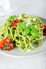 Pasta spaghetti with homemade pesto sauce, roasted tomatoes and fresh basil leaves, vegetarian food