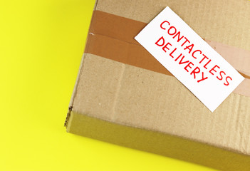 contactless delivery. parcel in hand on a yellow background