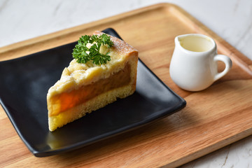 Cheesecake for break times on table with milk cup.