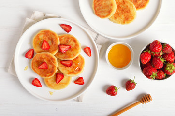 Cottage cheese pancakes with strawberry slices and honey