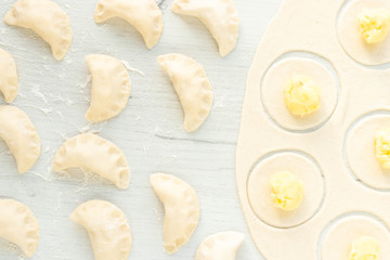 The process of cooking dumplings on a light background. Dumplings with potatoes on a wooden table. Mold dumplings. Top view