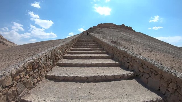 Yazd, Iran - May 2019: Tourists walking in the stairs of Ruins of Zoroastrians Dakhmeh Towers of Silence in Yazd city