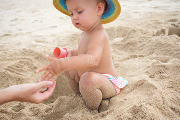 Adorable toddler girl playing with beach toys on white sand beach