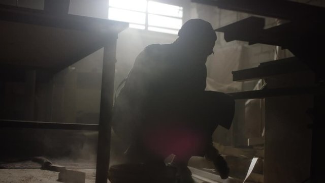 Mann fegt in seiner Werkstatt