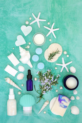 Fototapeta na wymiar Skincare beauty treatment with fresh rosemary herb and cosmetic products. With astringent & anti ageing benefits & helps to reduce environmental skin damage. Flat lay on turquoise.