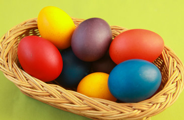 Easter eggs colors in basket green background