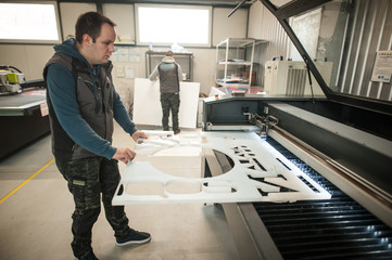 Technician works on Laser CNC computer numerical control cutting machine
