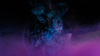 Color drop in water on black background