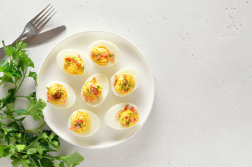 Stuffed eggs with egg yolk, bacon, mustard on plate