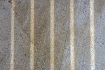 Concrete texture background with vertical shadows. Concrete slab with vertical stripes from sunlight.