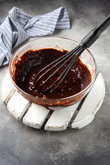 Preparation of chocolate dough for sweet pastries (pancakes, cupcakes, brownies), mixing of ingredients (milk, eggs, flour, cocoa)