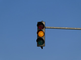 Yellow color on the traffic light with blue sky in background