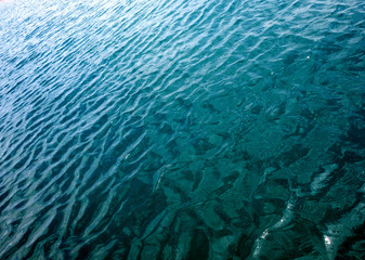 Ripples on water surface with reflections of sky and clouds. Simple minimal meditative marine landscape.